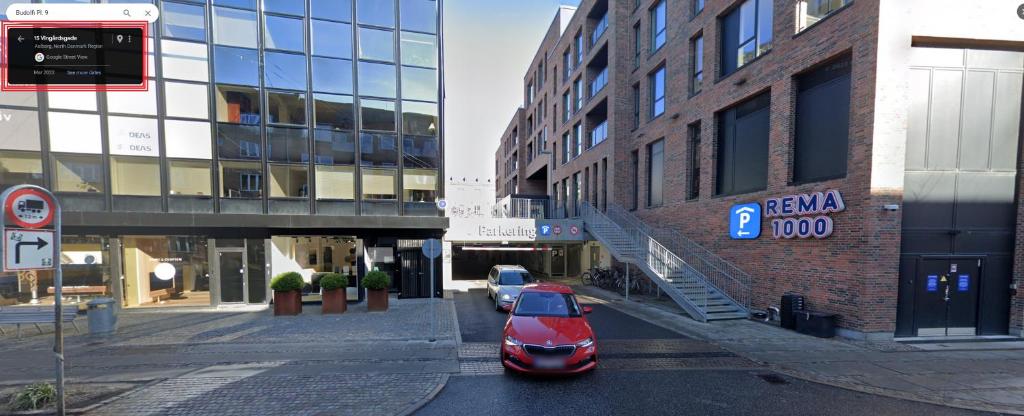 un coche rojo estacionado en una calle al lado de los edificios en Centralt Lejlighed i Aalborg C - Budolfi, en Aalborg
