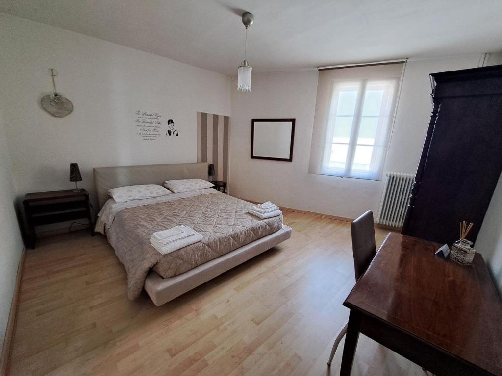 サン・ヴィート・アル・タリアメントにあるLa casa di Feliceのベッドルーム1室(ベッド1台、テーブル、窓付)