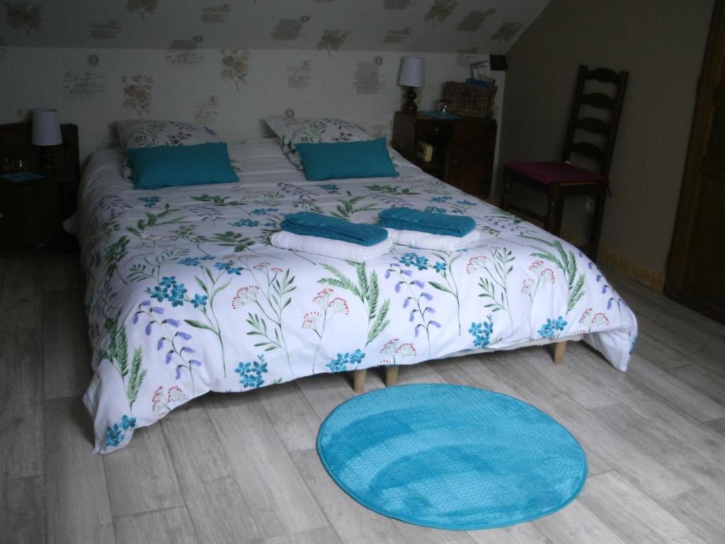 um quarto com uma cama com almofadas azuis e um tapete azul em Chambre Sologne em Saint-Julien-sur-Cher