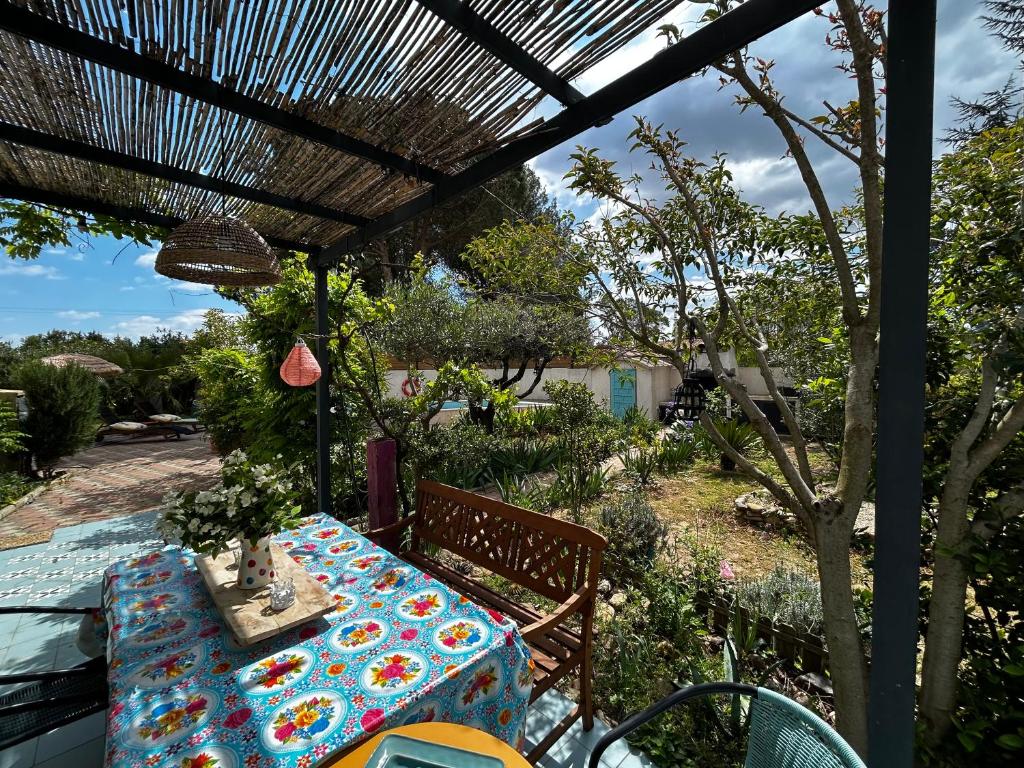 a table sitting under a pergola on a patio at Maison invitant aux voyages 20mn de la plage in Béziers