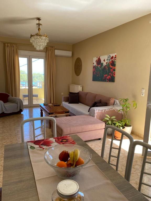 a living room with a table with a bowl of fruit on it at MARIA cozy apartments in Pigianos Kampos