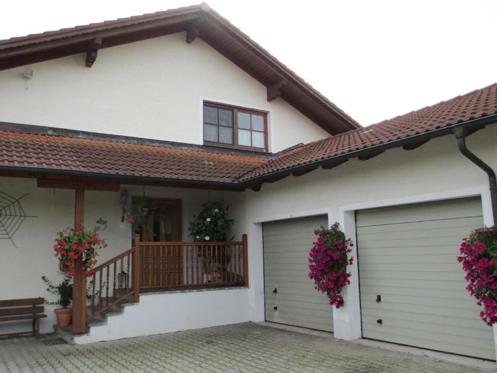 a house with two garage doors and flowers at Apartment für zwei Erwachsene und ein Kind mit Balkon - b57048 in Bad Füssing