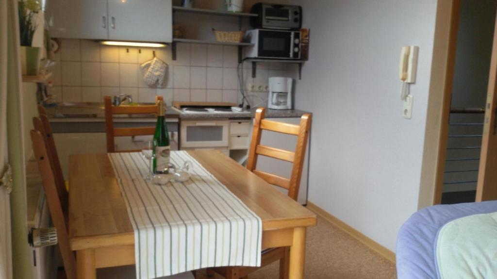 uma cozinha com uma mesa de madeira com uma garrafa em Wohnung in der ersten Etage mit Blick auf die Weinberge em Kröv