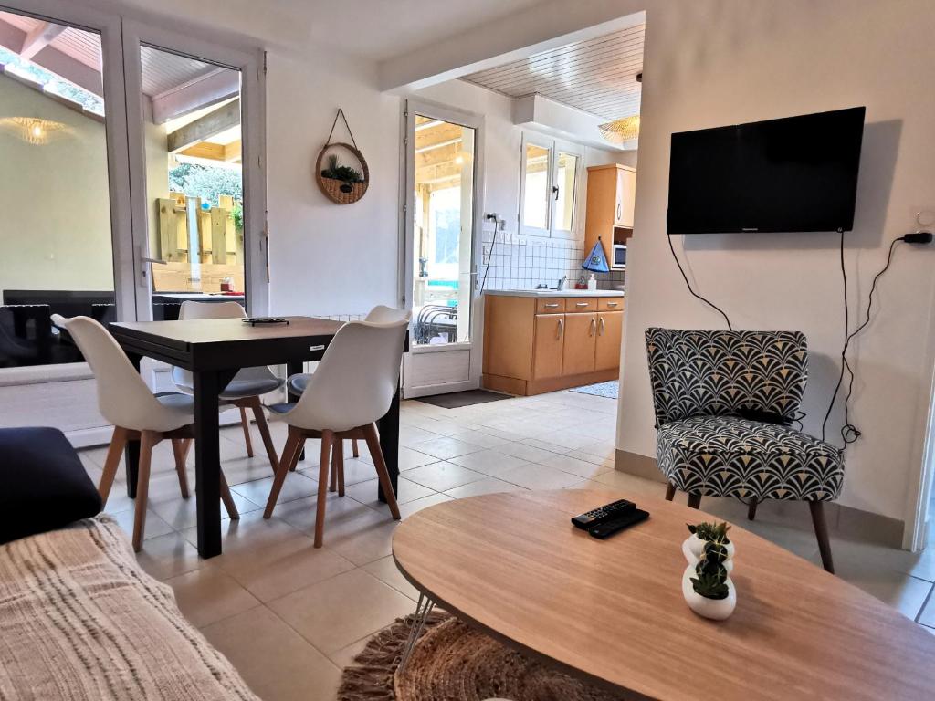 a living room with a table and a dining room at Entre mer et foret 2 in Jard-sur-Mer