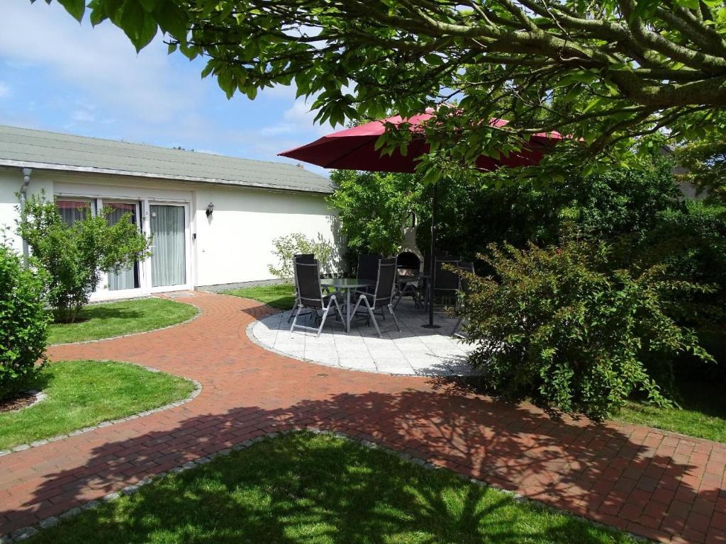 a patio with a table and chairs and an umbrella at Ferienwohnung 3 in Pudagla auf der Insel Usedom in Pudagla