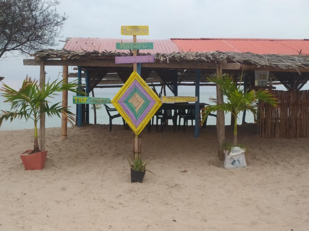 - un panneau de rue dans le sable sur la plage dans l'établissement Alojamiento Eco Tours Kaigee, à Mayapo