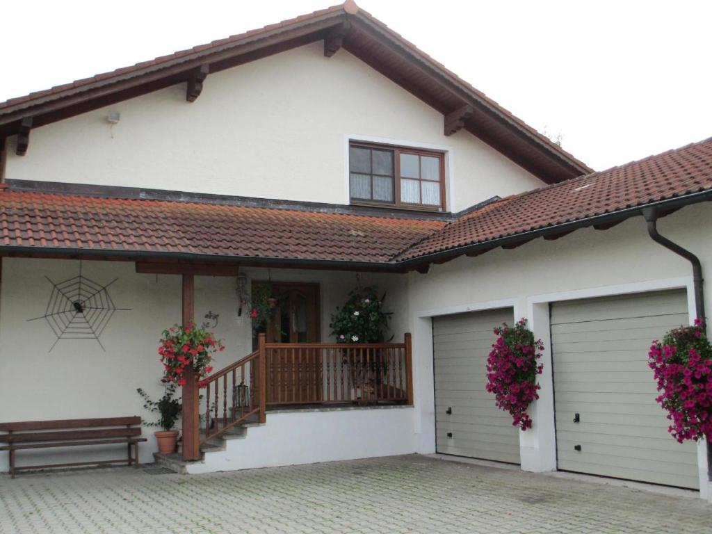 a house with a porch and garage at Apartment für zwei Erwachsene und ein Kind mit Balkon in Bad Füssing