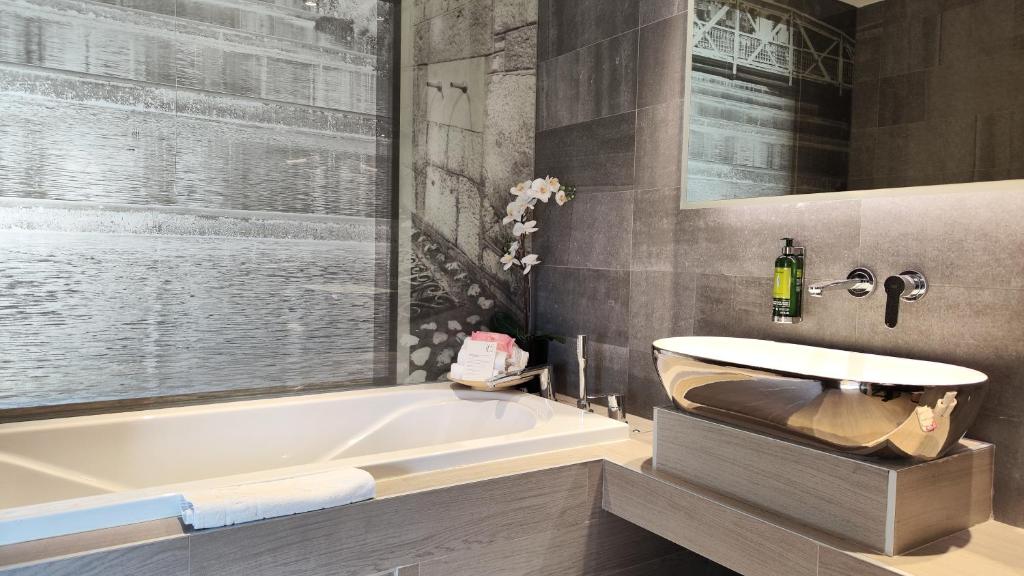 a bathroom with a tub and a sink at Hotel Colors Inn in Sarajevo