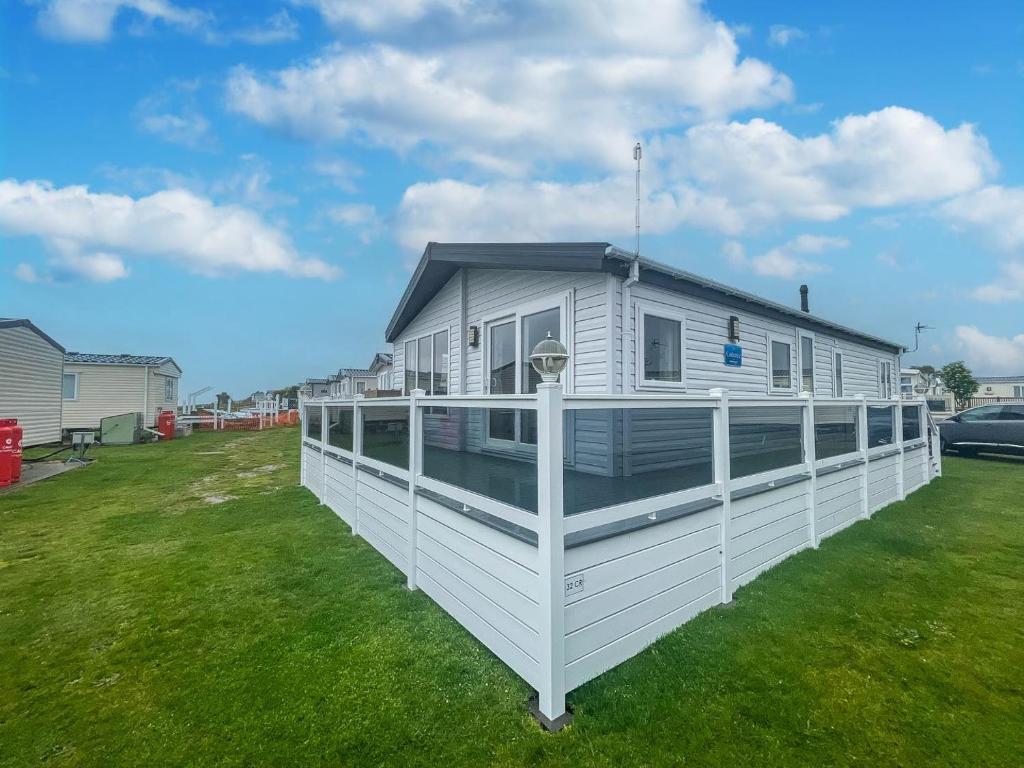 przyczepa mieszkalna z tarasem na trawniku w obiekcie Stunning 6 Berth Lodge With Partial Sea Views In Suffolk Ref 68007cr w mieście Lowestoft