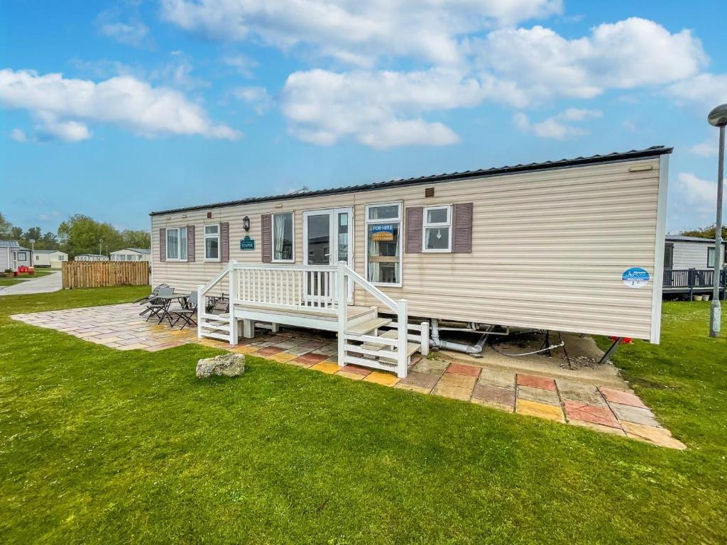 een stacaravan met een veranda en een gazon bij By The Seaside Dog Friendly Caravan At Haven Hopton In Norfolk Ref 80015w in Great Yarmouth