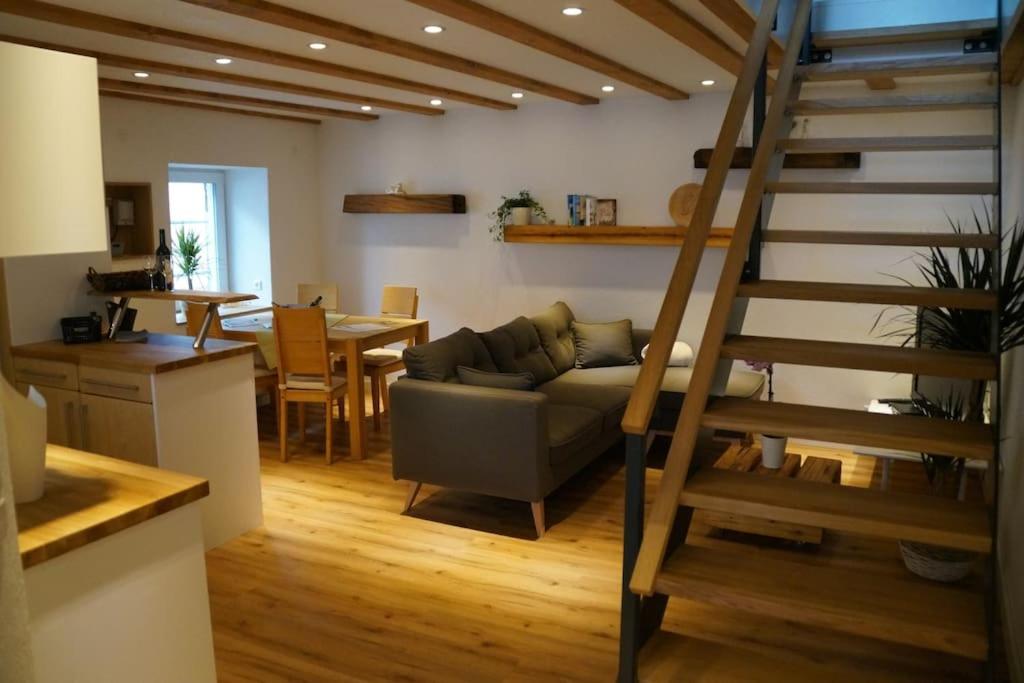 a living room with a couch and a spiral staircase at Ferienwohnung Sigwart in Efringen-Kirchen