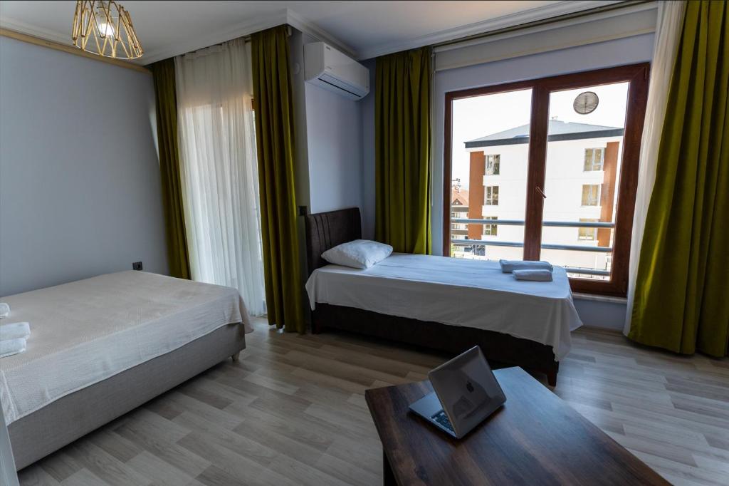 a hotel room with two beds and a window at Flora Trabzon Apart in Pelitli