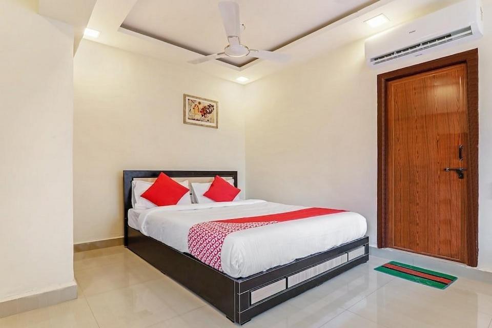 um quarto com uma cama com almofadas vermelhas em OYO KINGS HOTEL em Katunayaka