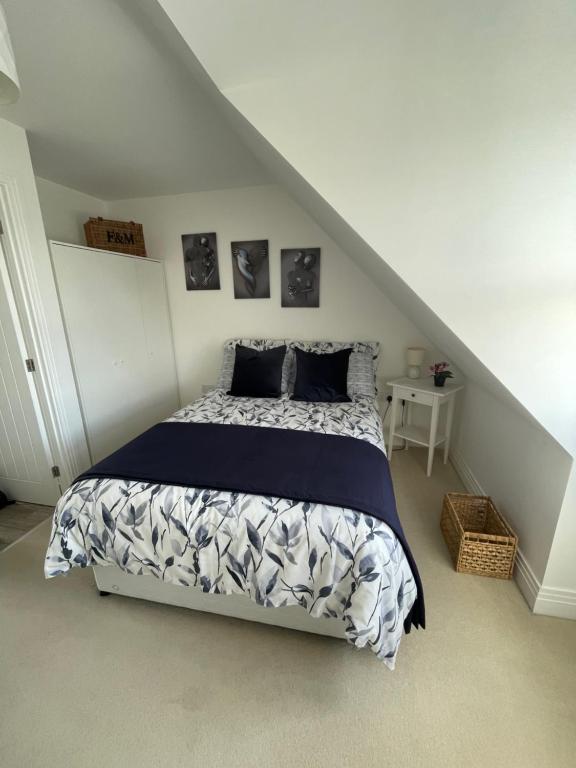 a bedroom with a bed with a blue and white comforter at Smith's Loft in Chichester
