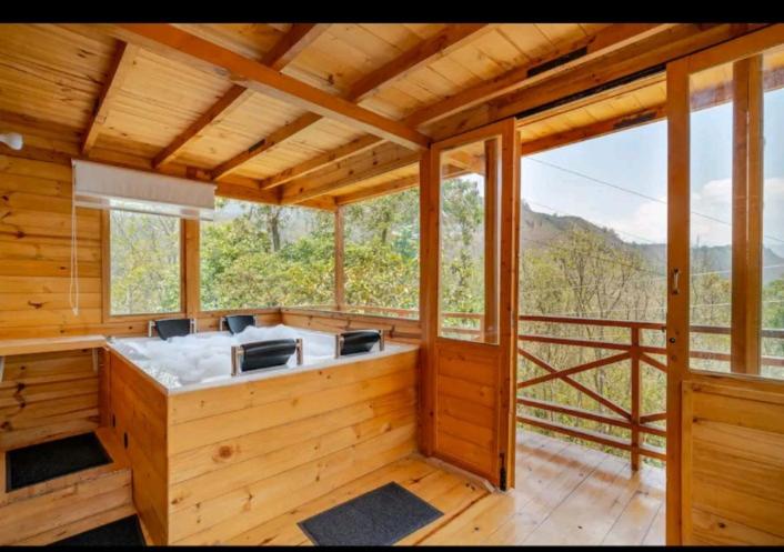 a kitchen in a wooden cabin with a balcony at Ecocabaña con Jacuzzi Ecocabañas ByB in Choachí