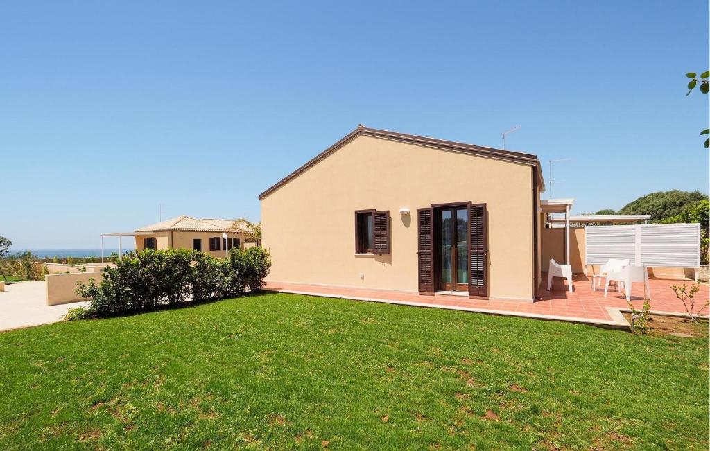 ein Haus mit einem Rasen davor in der Unterkunft Beach Front Home In Marina Di Modica in Marina di Modica
