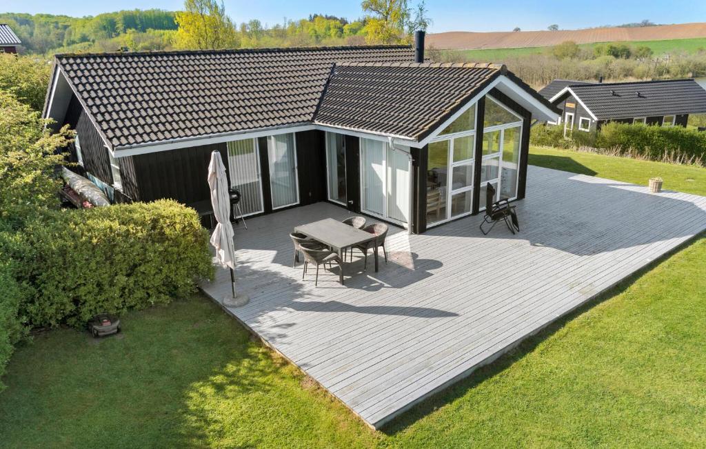 una casa con terrazza in legno e tavolo di Stunning Home In Haderslev With House Sea View a Haderslev