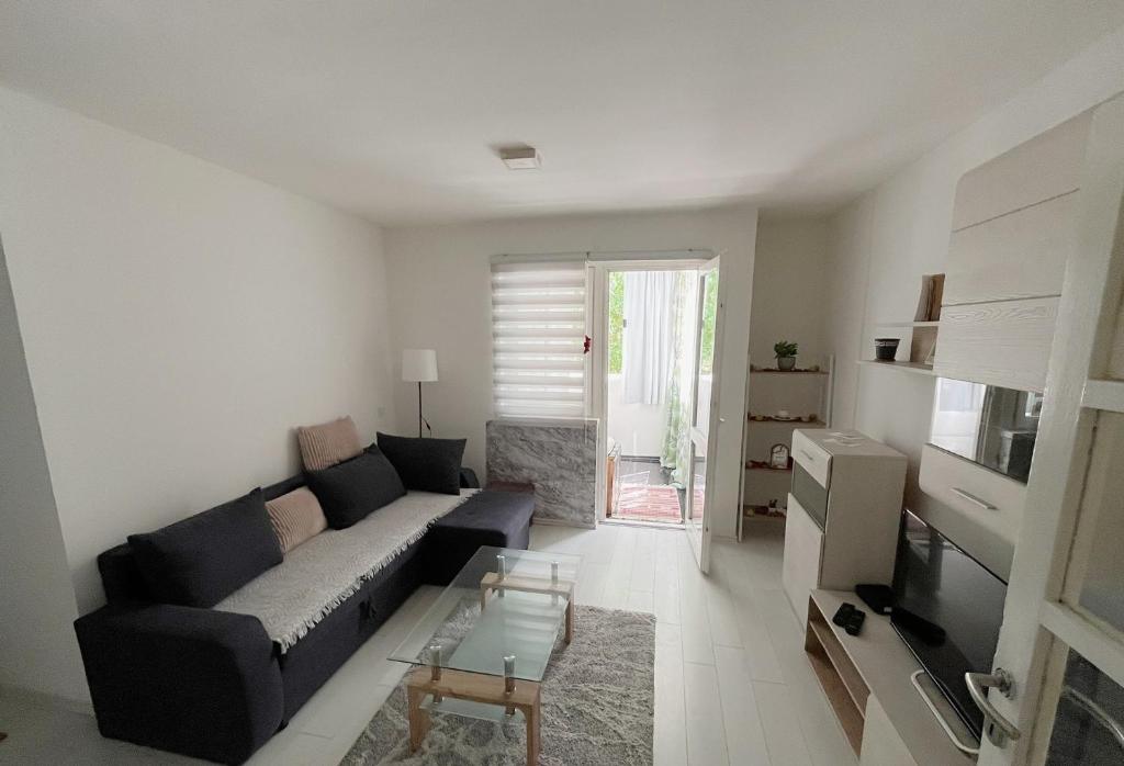 Grandeur Home Apartment Mostar في موستار: غرفة معيشة مع أريكة وطاولة
