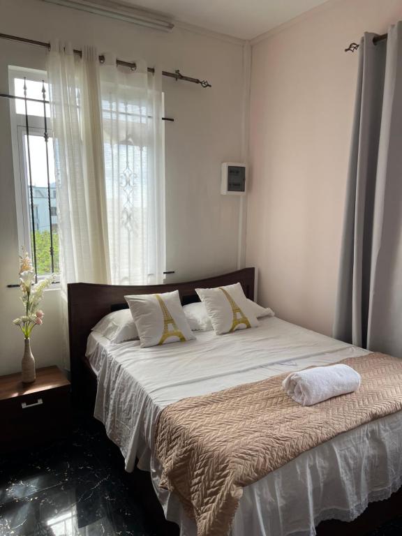 une chambre avec un grand lit avec une fenêtre dans l'établissement Cozy Apartment with Pool & 10 mins walk to Beach, à Mont Choisy