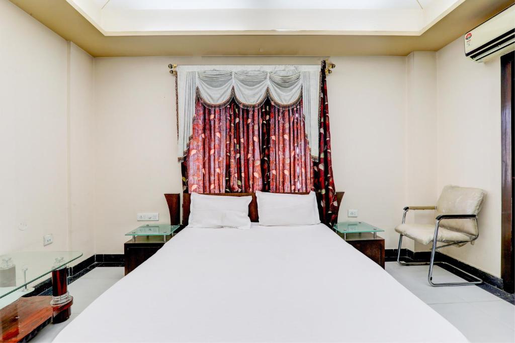 Un dormitorio con una cama grande y una ventana en OYO Hotel M & c, en Patna