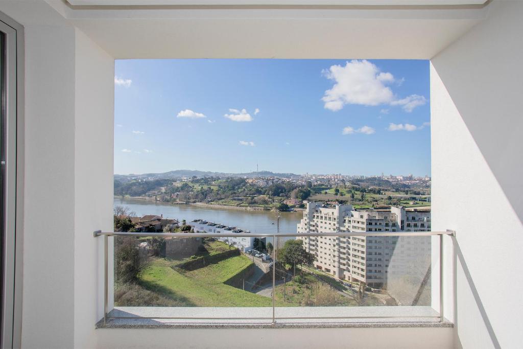 een raam met uitzicht op een rivier en gebouwen bij Inviting - Douro Vista Apartments in Valbom