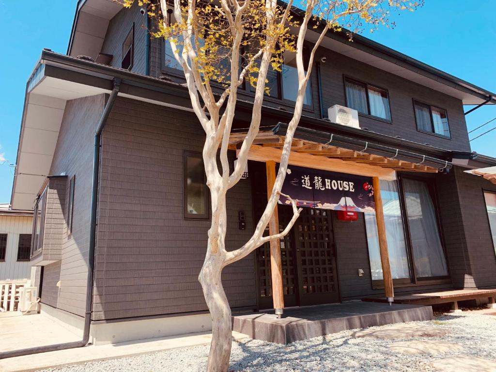 a building with a tree in front of it at 道龍house in Azagawa