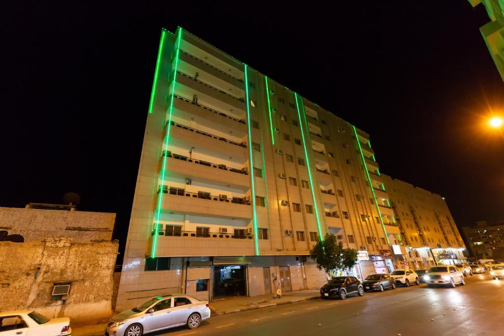 a large building with cars parked in front of it at العييري للشقق 014 يومي وشهري بالمدينة in Al Madinah