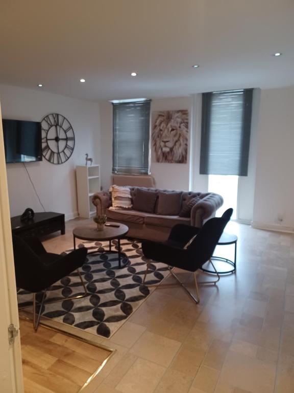 a living room with a couch and a table and chairs at Q Flat Skyview Spacious in Bradford