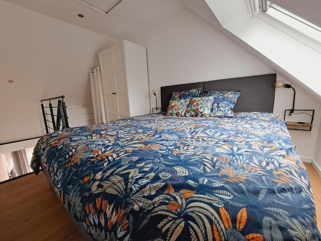 una camera da letto con un grande letto e un piumone colorato di Studio Pleuven a Pleuven