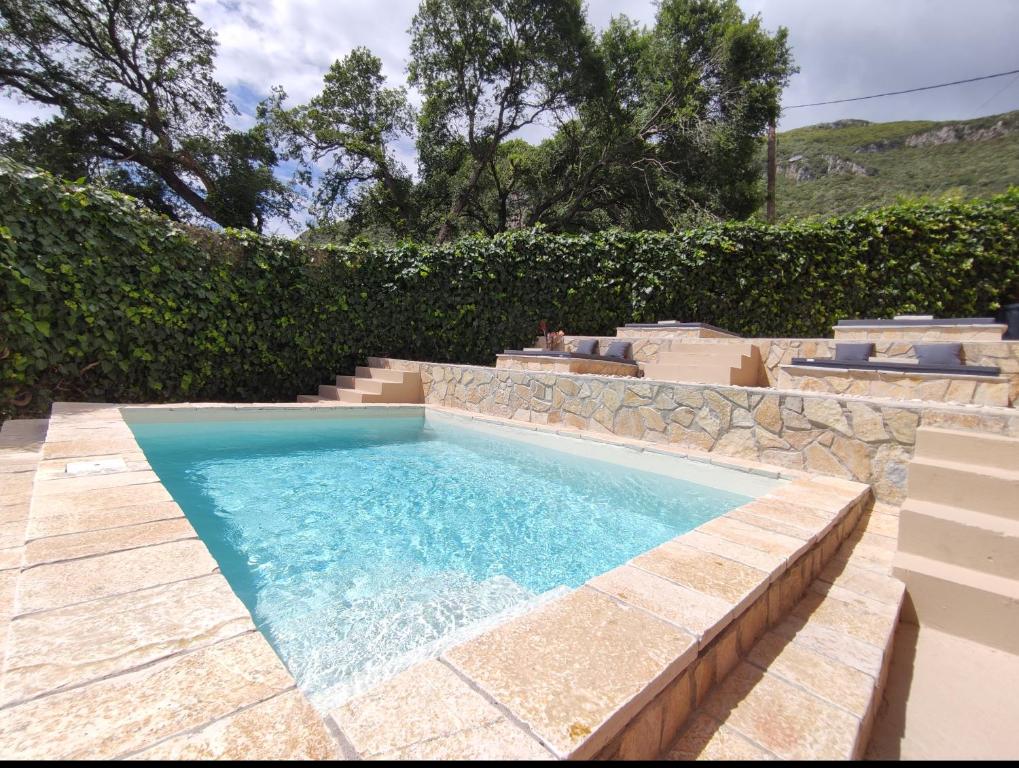 una piscina en un patio con una pared de piedra en GKK House private swimming pool luxury house en Skriperón