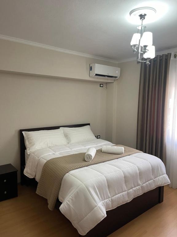 a bedroom with a large bed with white sheets at Cozy City Studio in Gjirokastër