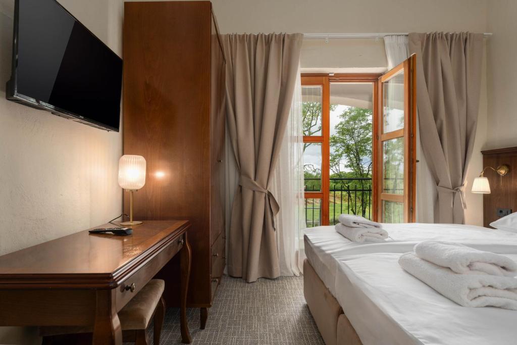Una habitación de hotel con dos camas, un escritorio y una ventana. en Boutique Hotel Paradiso, en Poreč