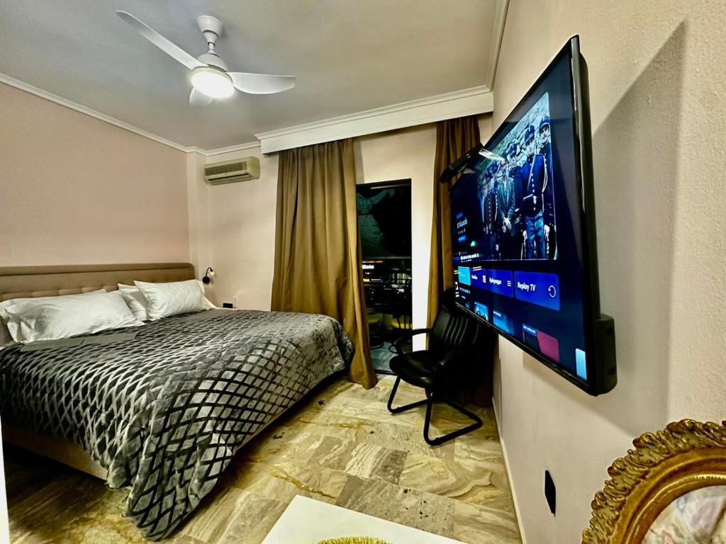 Un dormitorio con una cama y un televisor de pantalla plana. en TRAVELLERS JULIUS STUDIO DOWN TOWN Thessaloniki University, en Tesalónica