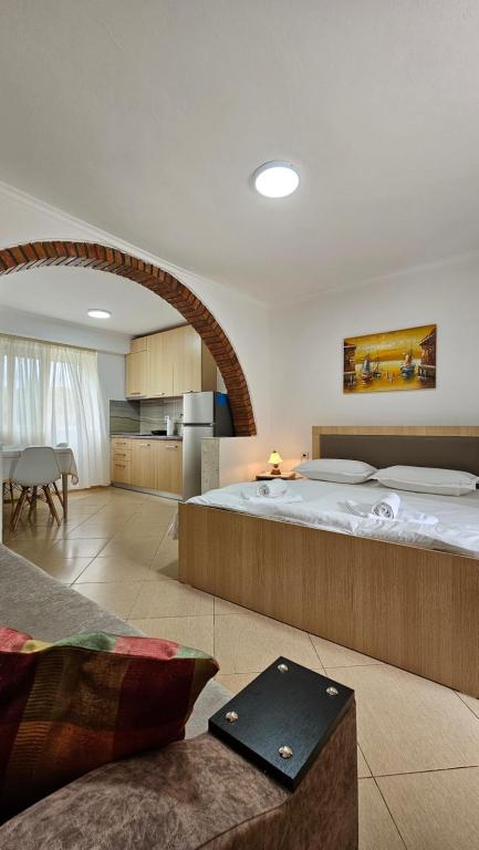 a bedroom with a large bed and a kitchen at Aliaj's Guest House in Berat