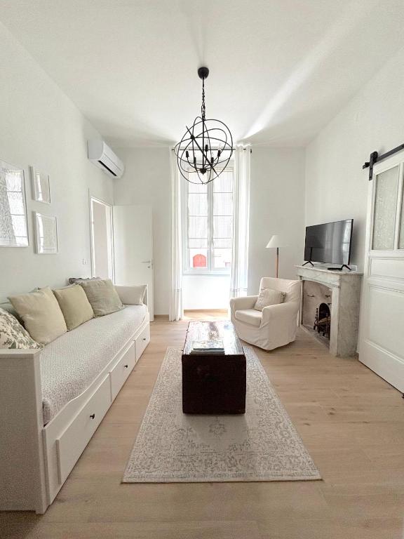 a white living room with a couch and a tv at Casa verde in Ventimiglia