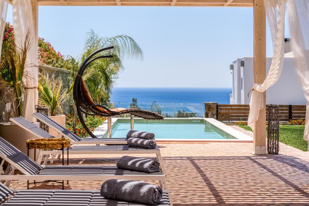 una piscina con tumbonas y vistas al océano en Heliophos Villa Aelia, en Kiotari