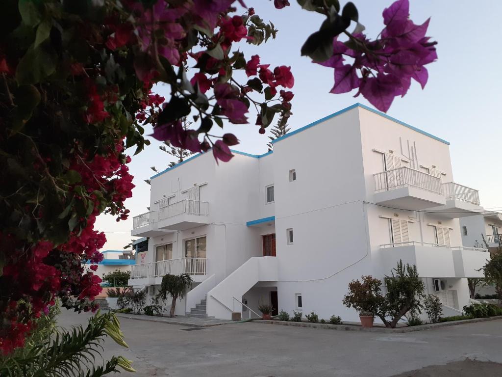a white building with flowers in front of it at Your Second Home 2 in Kámpos