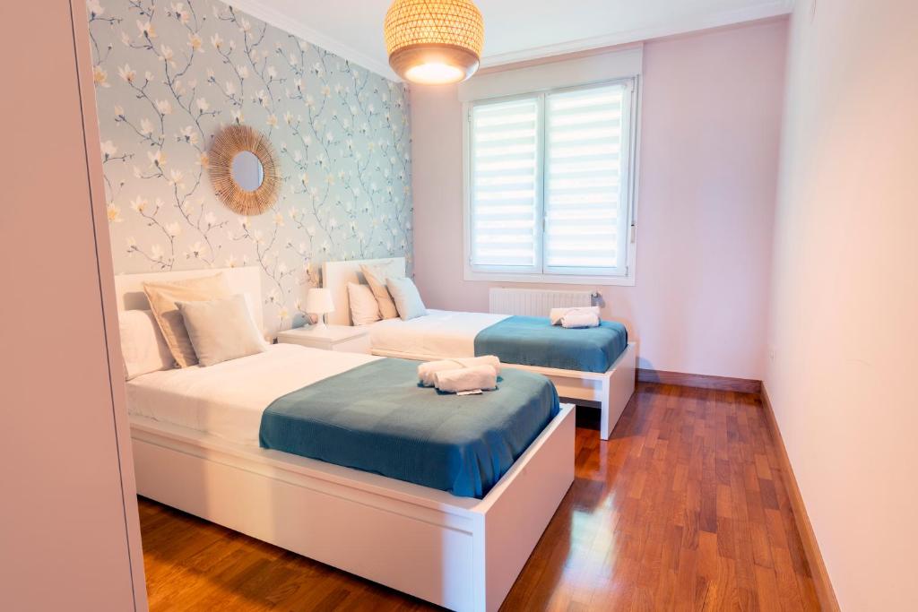 1 dormitorio con 2 camas y sofá en Bonbillo - ONGI ETORRI, en Zumaia