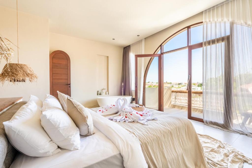 una camera da letto con un grande letto con una grande finestra di Amani Villas: New, Luxury, Mediterranean, Private Pool, Canggu a Canggu