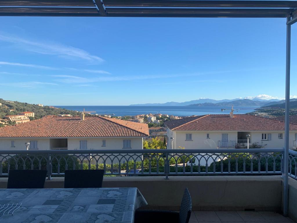 einen Balkon mit Aussicht, einem Tisch und Stühlen in der Unterkunft T2 clim 54m2, 17m2 de terrasse très belle vue mer in LʼÎle-Rousse