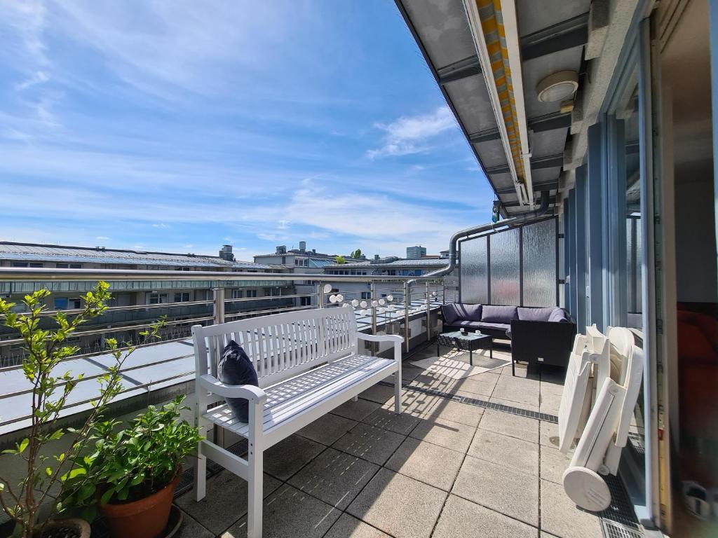 Eine Katze sitzt auf einer Bank auf einem Balkon in der Unterkunft Ridler! Theresienwiese Oktoberfest, parking & rooftop terraces 2 room in München