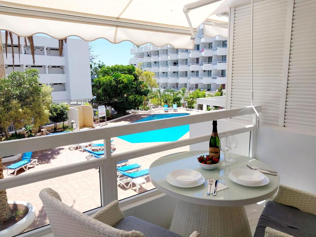 - une table avec une bouteille de vin sur le balcon du complexe dans l'établissement RELAX, à Playa de Fañabé