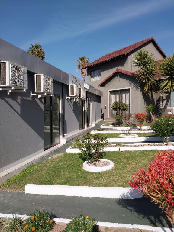 a building with a yard with plants and flowers at Alimop Bed and Breakfast in Midrand