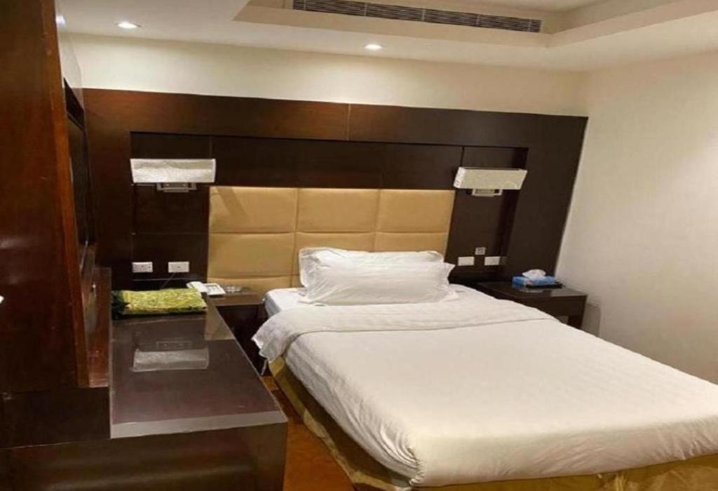 a bedroom with a large bed with a large headboard at شقق الفرسان حي السلامة in Jeddah
