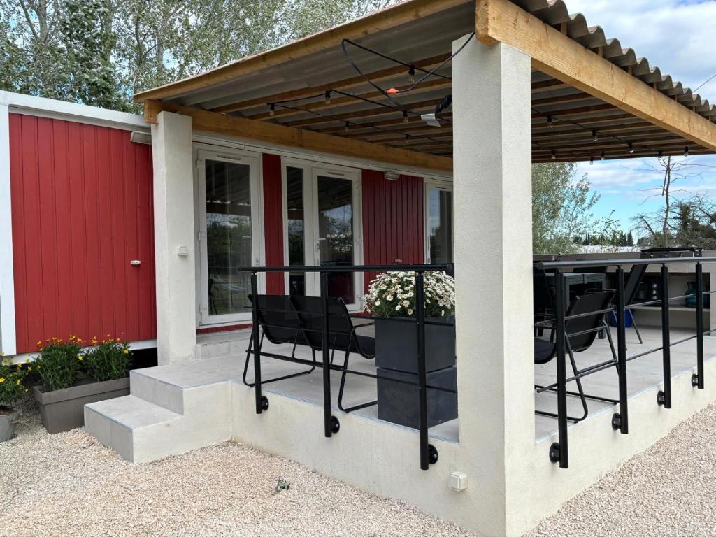 une pergola avec une table et des chaises sur une terrasse dans l'établissement Location de vacances en campagne avec accès piscine, à Beaucaire