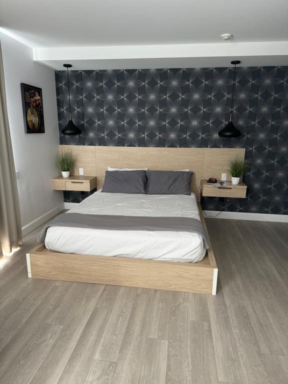 a bedroom with a large bed and two tables at La Porte de la Mauricie in Louiseville