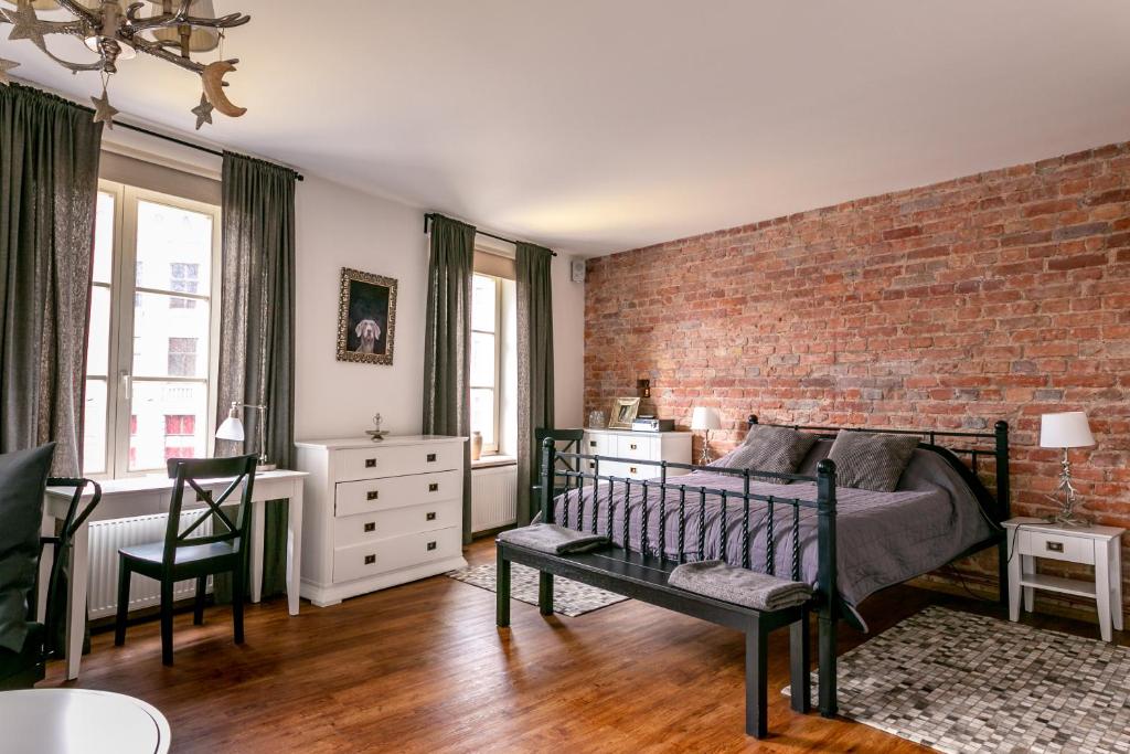 Un dormitorio con una pared de ladrillo y una cama en Ars Vivendi Rezidence, en Riga