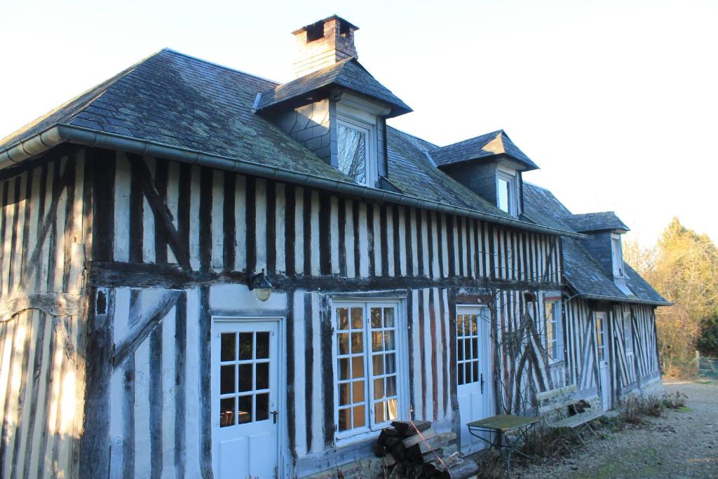 un ancien bâtiment bleu et blanc avec un toit dans l'établissement Gris Pomme Gite du Manoir de la Porte, à Les Authieux-sur-Calonne