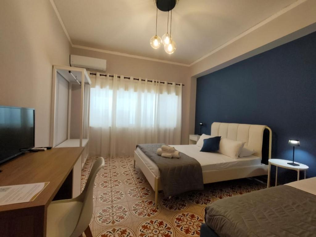 una camera da letto con un letto, una TV e un divano di Luma casa Vacanze Cefalù a Cefalù