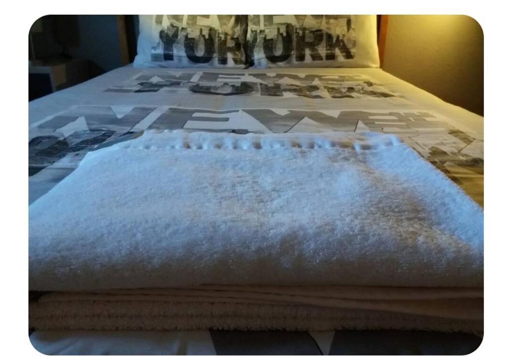- un lit avec une couverture blanche dans l'établissement Apartamento Near airport, à La Laguna